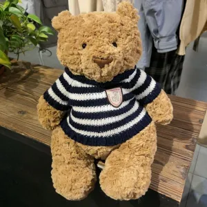 Süßer brauner Teddybär Plüschtier mit kuscheligem blau-weiß gestrickten Pullover für Kinder.