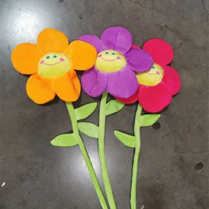 Primo piano di fiori di peluche sorridenti colorati con steli verdi, tessuto morbido e dettagli carini.