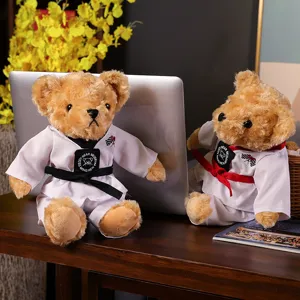 Adorable peluche d'ours en peluche taekwondo portant un uniforme dobok blanc avec ceinture.