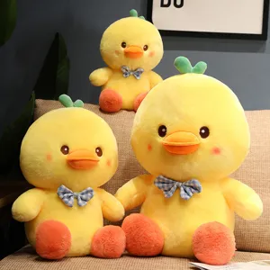 Cute yellow duck plush toy with blue plaid bow and green leaf, soft stuffed doll for kids.