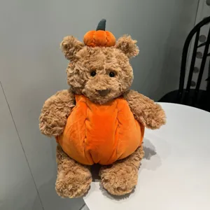 Vista dettagliata del simpatico orsetto di peluche zucca, morbida bambola per Halloween.