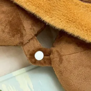 Almohada de viaje de peluche marrón con capucha, cojín cervical suave con cierre de botón a presión.