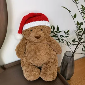 Detaillierte Ansicht des süßen braunen Plüsch-Teddybären mit festlicher rot-weißer Mütze.