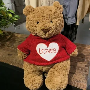 Nahaufnahme eines süßen braunen Plüschteddybären im roten Strickpullover mit Herz.