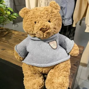 Plüsch Teddybär Spielzeug mit weichem braunem Fell und süßem hellblauem Strickpullover.