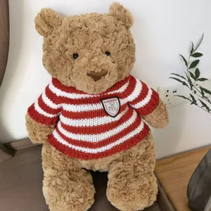 Niedlicher brauner Plüsch-Teddybär mit gemütlichem rot-weißen gestreiften Strickpullover.