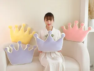 Detail view of the cute crown shaped plush pillow in a cozy home setting, soft fabric.