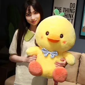 Cute yellow duck plush toy with blue bow tie and green sprout, soft stuffed animal doll for kids.