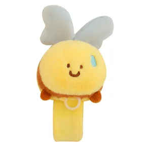 Cute cartoon bee plush slap bracelet with soft fabric wings and attached plastic ring toy.