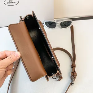 Bolso cruzado marrón de cuero PU con forma única y correa ajustable para las mujeres.