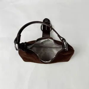 Vista detallada del interior y la cremallera del bolso retro de ante marrón para mujer.