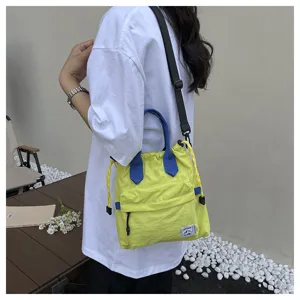 Vue détaillée du sac seau à cordon décontracté avec anses bleues et bandoulière réglable.