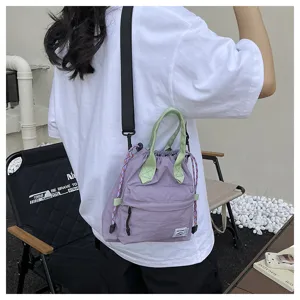 Détail de sac seau en toile décontracté, corps violet et poignées vertes pour tous les jours.