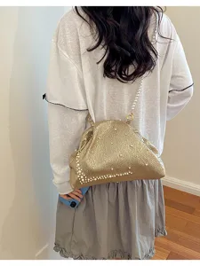 Vue détaillée de la pochette dorée plissée tendance avec élégante chaîne en perles.