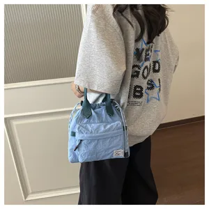 Sac seau casual bleu clair avec poignées vert foncé et poche avant pour le quotidien.