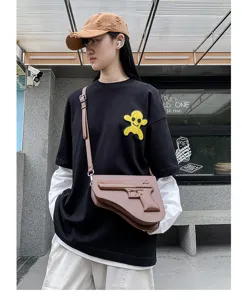 Vista detallada del bolso cruzado de moda en forma de pistola con estilo streetwear.