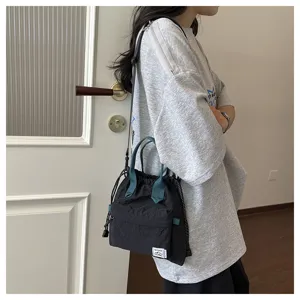 Gros plan sur les details du sac seau en nylon decontracte avec poignees vertes et cordon.