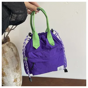 Vue detaillee d'un sac seau violet tendance dote de poignees vert vif et de cordons elegants.