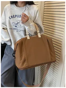 Detailed view of the large capacity brown travel duffel bag with handles and shoulder strap.