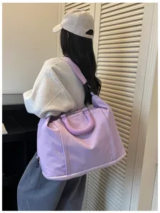Detail view of the large capacity travel duffel bag in light purple with shoulder strap.