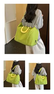 Details of large capacity green travel shoulder bag with yellow handle and portable design.