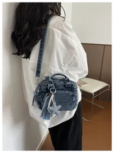 Denim boston bag detail shot showing stylish crossbody design with cute pearl star charm pendant.