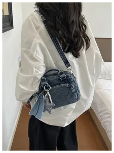 Stylish denim boston bag for women, trendy crossbody and shoulder handbag with chic charms.