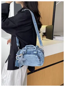 Close-up view of the stylish denim Boston bag with shoulder strap and cute star charm detail.