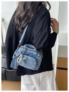 Denim boston bag detail showing shoulder strap, zipper and cute star pearl pendant design style.