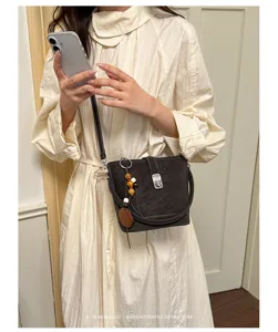 Sac seau rétro pour femme, élégant sac bandoulière tendance avec pendentif perles et fermoir.