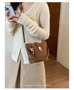 Vue détaillée du sac seau rétro pour femme avec pendentif de perles dans une scène quotidienne.