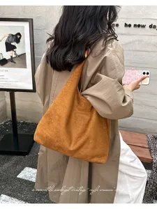 Detail shot of a brown suede vintage tote bag, casual commuting large capacity shoulder bag for women.