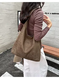 Detailed view of the vintage brown suede hobo shoulder bag in outdoor setting style.