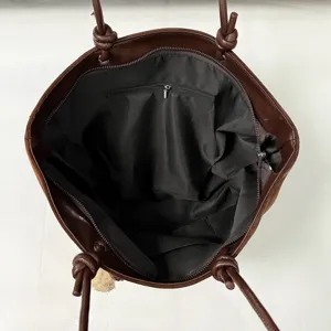 Brown leather tote bag interior detail, spacious single-shoulder handbag with zipper pocket.