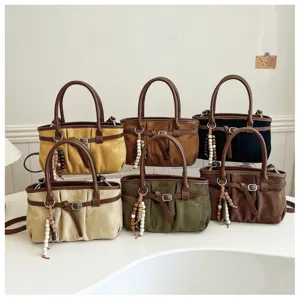 Détail de sac à épaule froncé vintage montrant plusieurs coloris avec pendentif perlé.