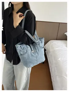 Λεπτομέρεια τσάντας ώμου denim με μοναδικό σχεδιασμό τσέπης και μεταλλικό λουκέτο.