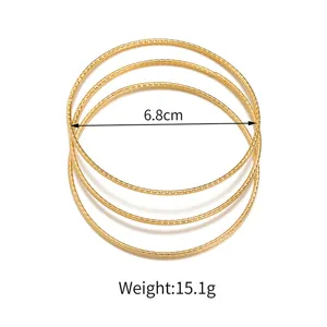 Stapelbare goldfarbene strukturierte Armreifen im eleganten minimalistischen Design.