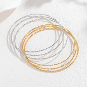 Stapelbare gedrehte Armreifen Set, elegante Gold- und Silbermetallarmbänder für Damenkleidung.