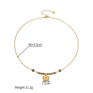 Close-up detail of gold flower pendant necklace with beads, showing chain length and sizes.