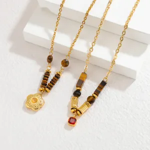 Close-up detail of multi-element retro gold pendant necklaces with decorative stone beads.