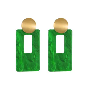 Pendientes geométricos elegantes con rectángulo de resina verde y círculo metálico dorado.