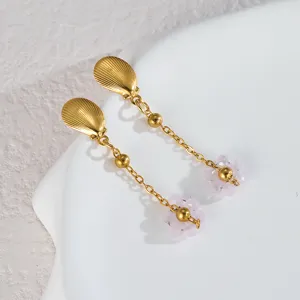 Primo piano dettaglio in acciaio inossidabile conchiglia dorata e orecchini di fiori.