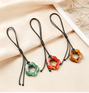 Gedetailleerd overzicht van natuursteen holle bloemhangers met zwarte gevlochten koorden.