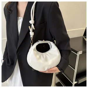 Primo piano di una borsa a mano bianca a mezzaluna con tracolla annodata e stile chic.