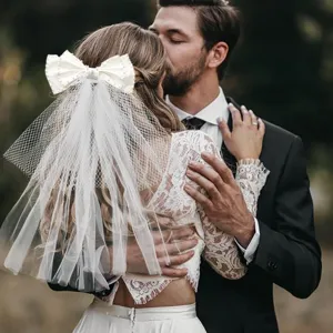 Fermaglio per capelli con fiocco bianco da sposa e corto velo nuziale per feste di addio al nubilato.