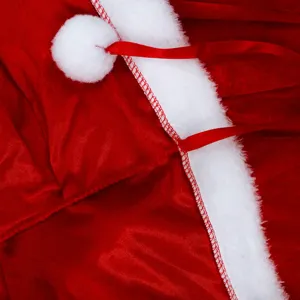 Close-up detail of red Christmas cape plush trim and pom-pom festival costume accessory.