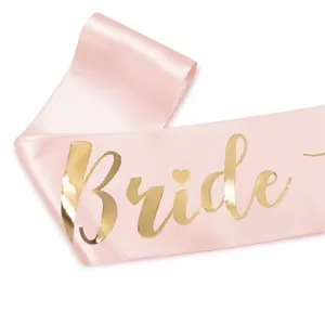 Κοντινό πλάνο σε ροζ σατέν ζώνη bachelorette με χρυσά γράμματα Bride λεπτομέρεια.