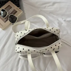 White polka dot ita bag detail showing interior compartment and clear front pocket.