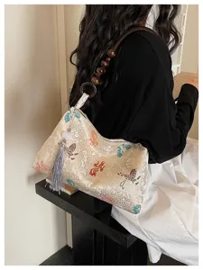 Chinese style brocade shoulder underarm bag with wooden bead handle and elegant tassel pendant.