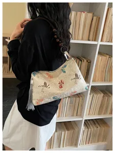Detailed view of Chinese vintage brocade shoulder bag with beaded strap and tassel.